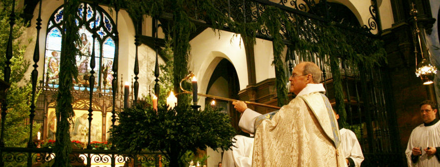 Fr. Parke lighting the Advent Wreath at the Christmas Eve Mass